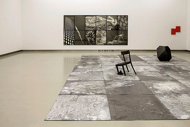 Ausstellung grosser Raum mit einem Bild und einer Bodeninstallation mit Sessel